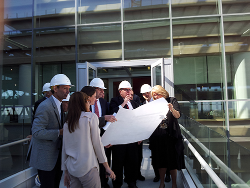 MAAC members review the Jordan Center blueprints with Senior Vice Dean Gail Morrison, M'71, FEL'76, while looking out on the structure of the Jordan Center.