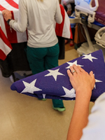 Hand over top of folded American flag