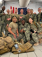 Members of the Navy-Trauma partnership posing in their uniforms in front of the U.S. flag