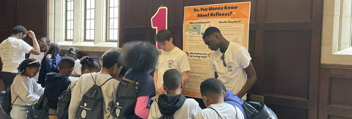 Two student volunteers teaching third grade students about reflexes on Penn's campus