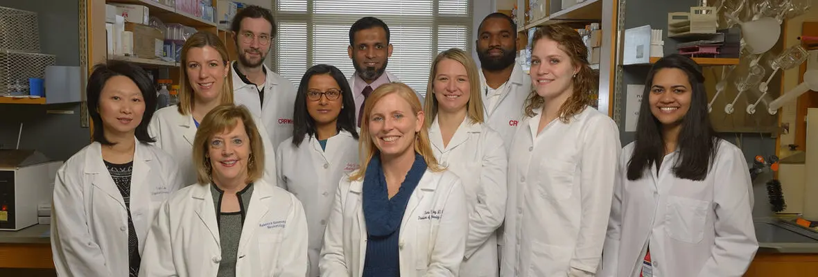 A group photo of researchers wearing white lab coats