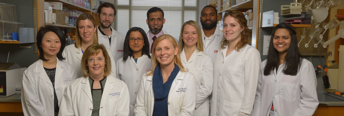 A group photo of researchers wearing white lab coats