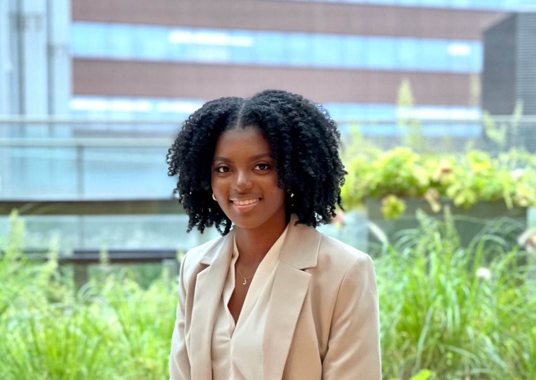 woman wearing beige blazer in front of a building.