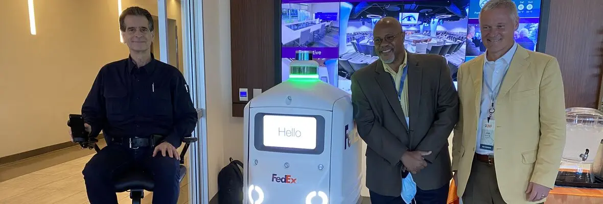 Johnson poses with a FexEx delivery Robot