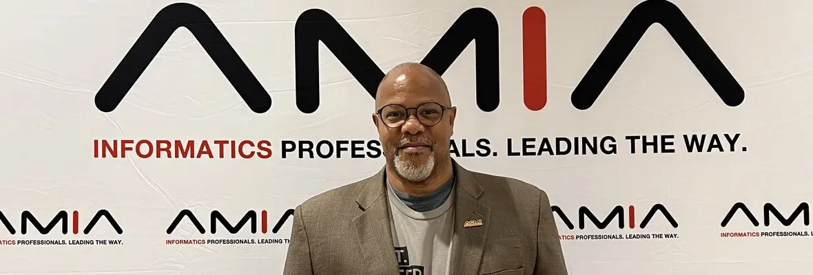 Dr. Johnson in front of an American Medical Informatics Association Banner