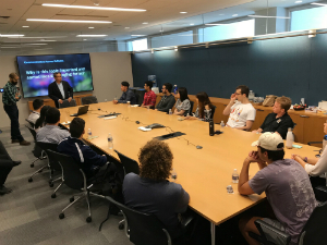 students sitting at table listeing to presentation