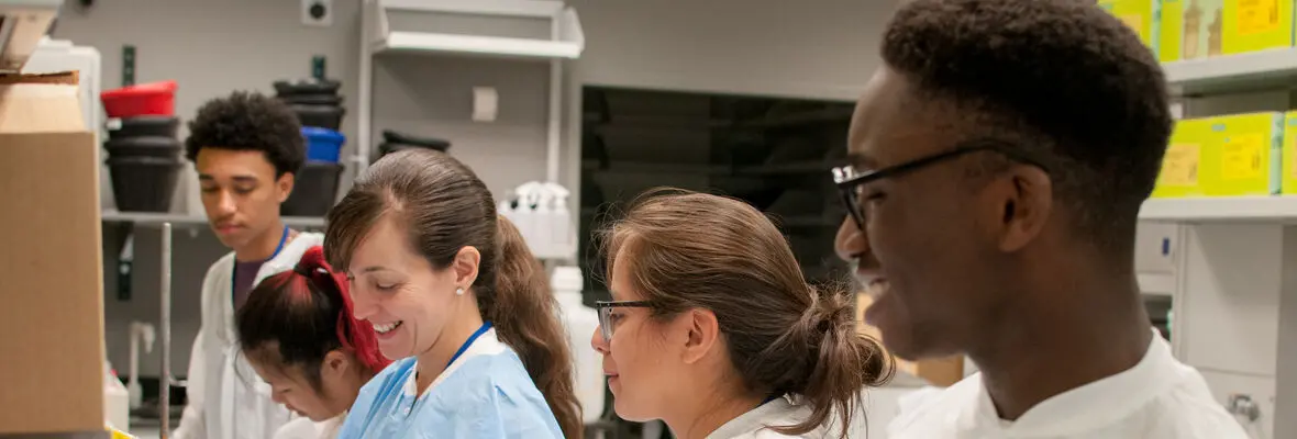 Trainees learning alongside a post-doctoral fellow at the bench