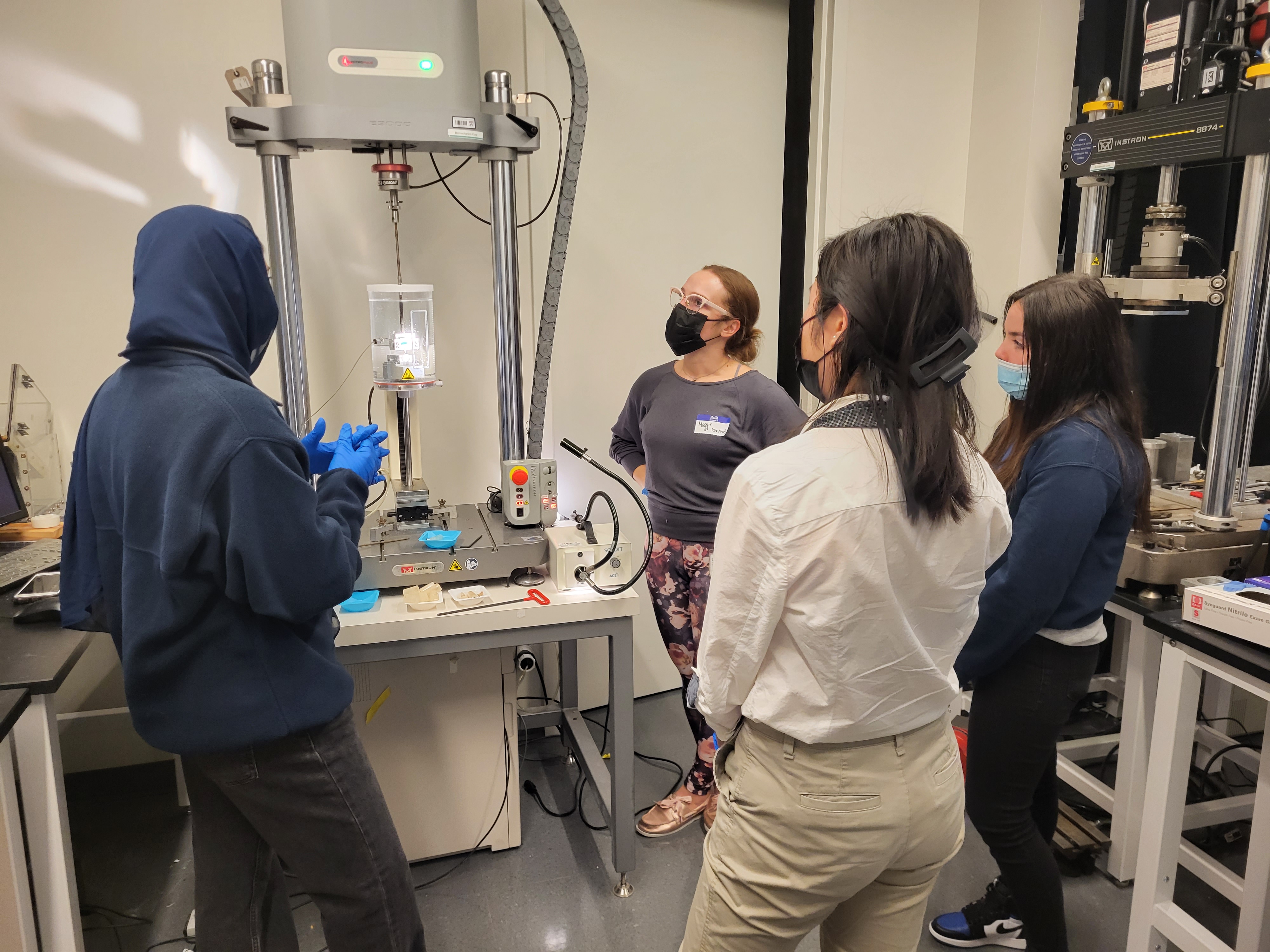 Students surrounding instron mechanical tester