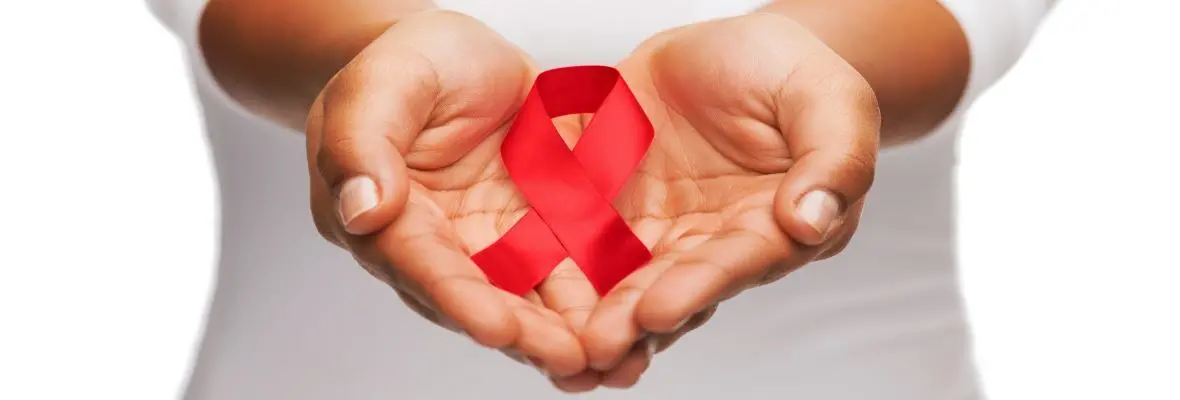 Hands holding red AIDS awareness ribbon