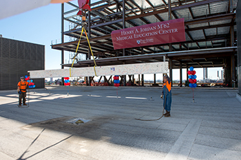 The final beam is hoisted into place in the Henry A. Jordan M'62 Medical Education Center.