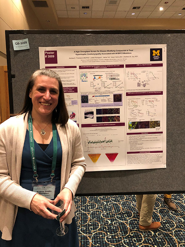 A woman standing in front of a scientific poster at a conference