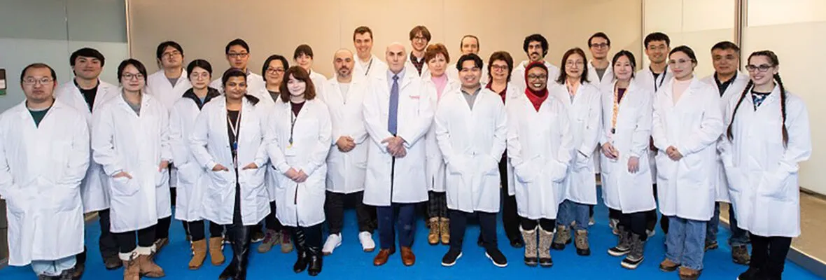 lab members standing together, wearing lab coats