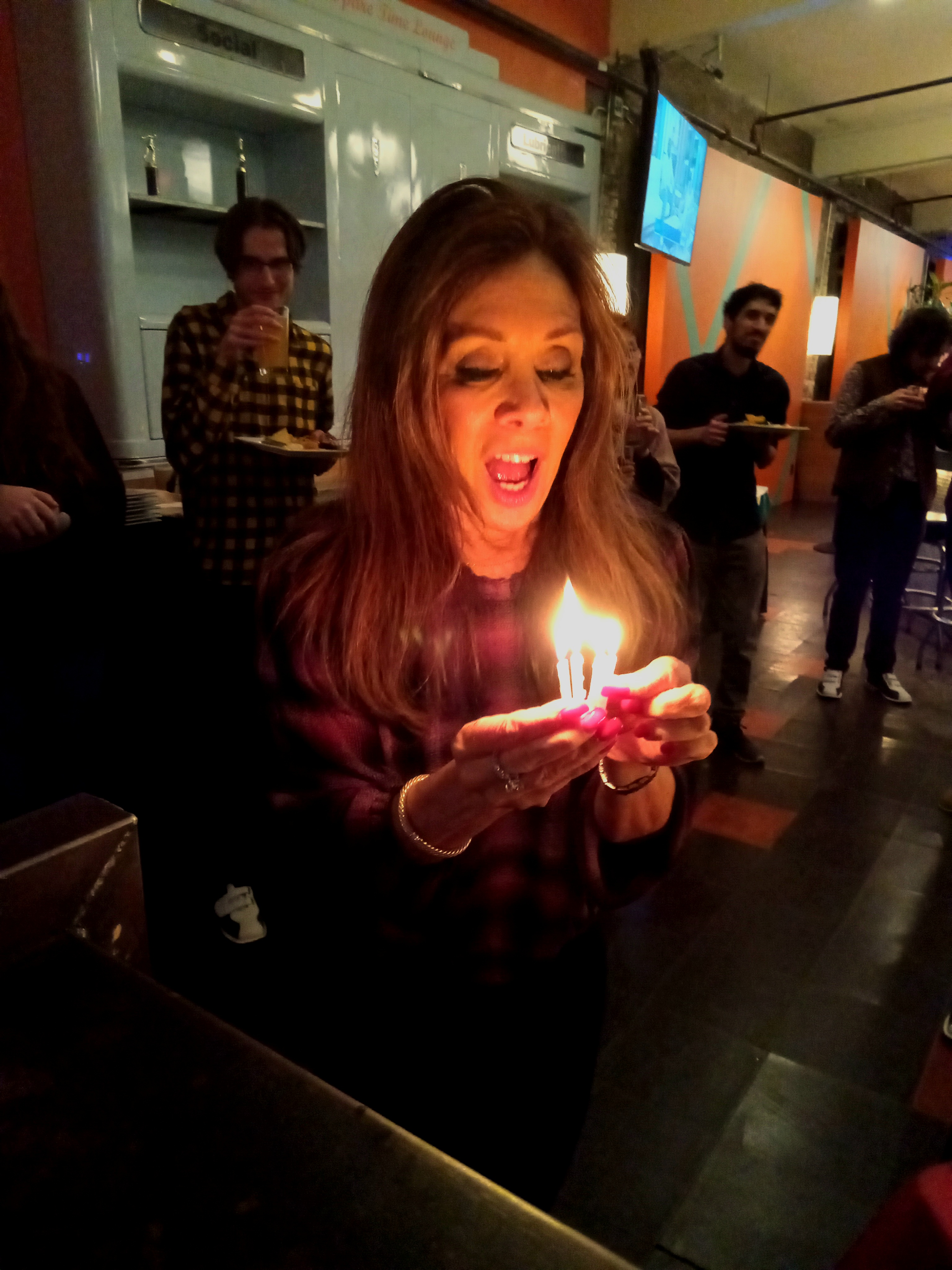 picture of lab member holding lit birthday candles to put on a cake