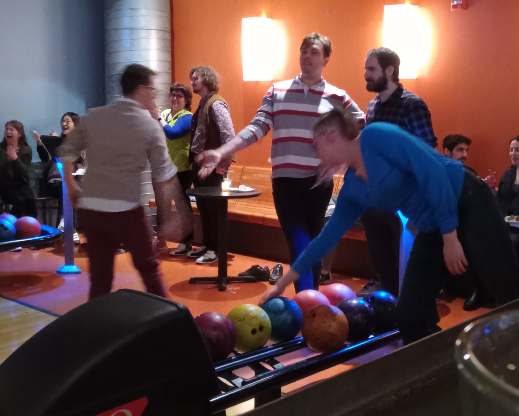 Picture of several lab members in the bowling lanes as they talk and bowl