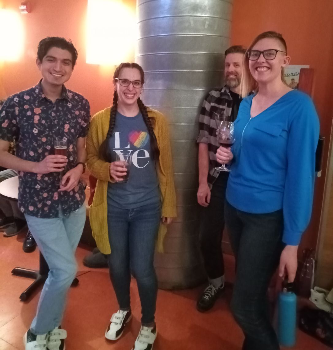 Four lab members stand together and smile for the photo in the bowling alley