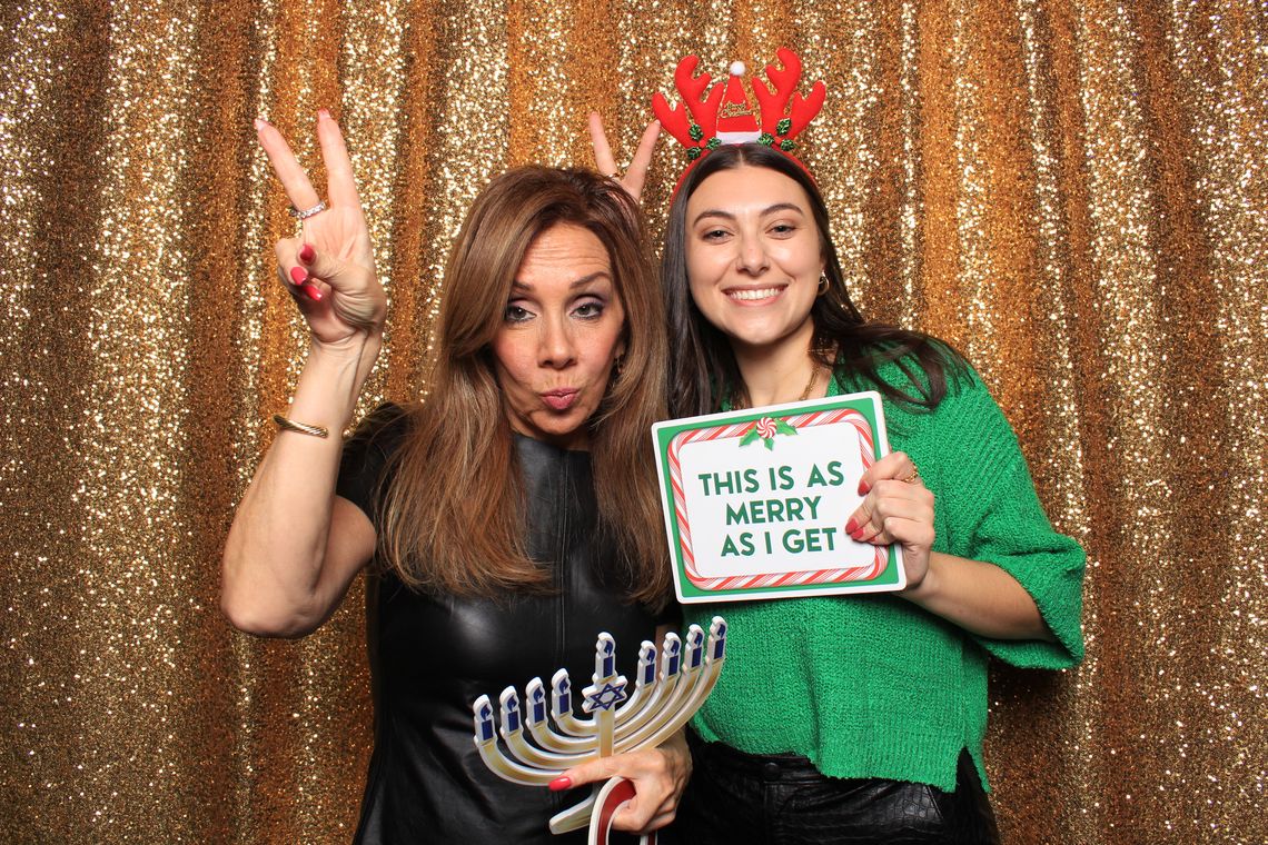 Two people smile and pose in photo booth