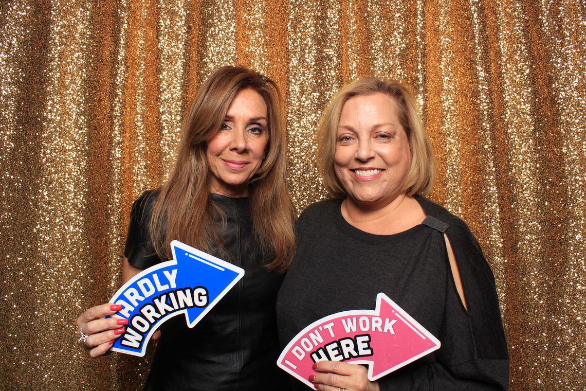 Two people smile and pose in photo booth