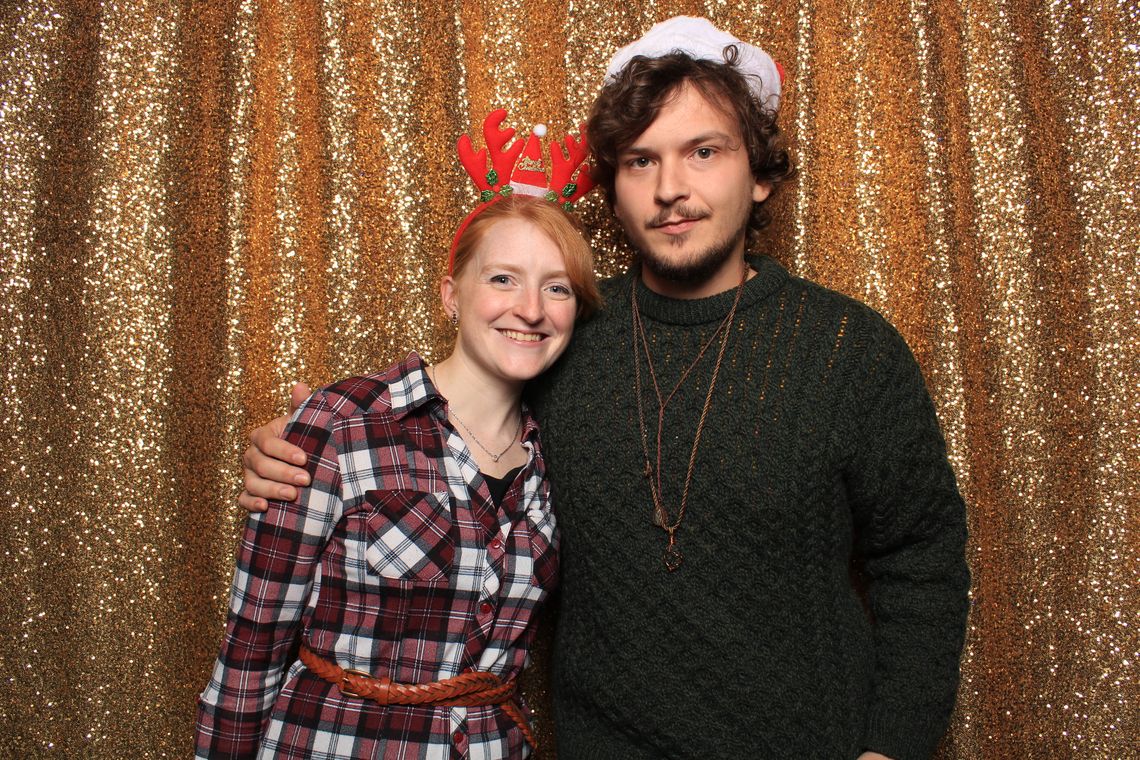 Two people smile and pose in photo booth