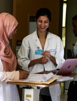 Dr. in whitecoat working with another woman, both smiling